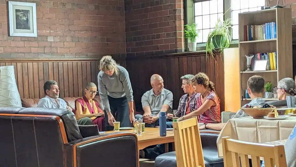 Group of people smiling an chatting being friendly in Vajrapani Buddhist Centre